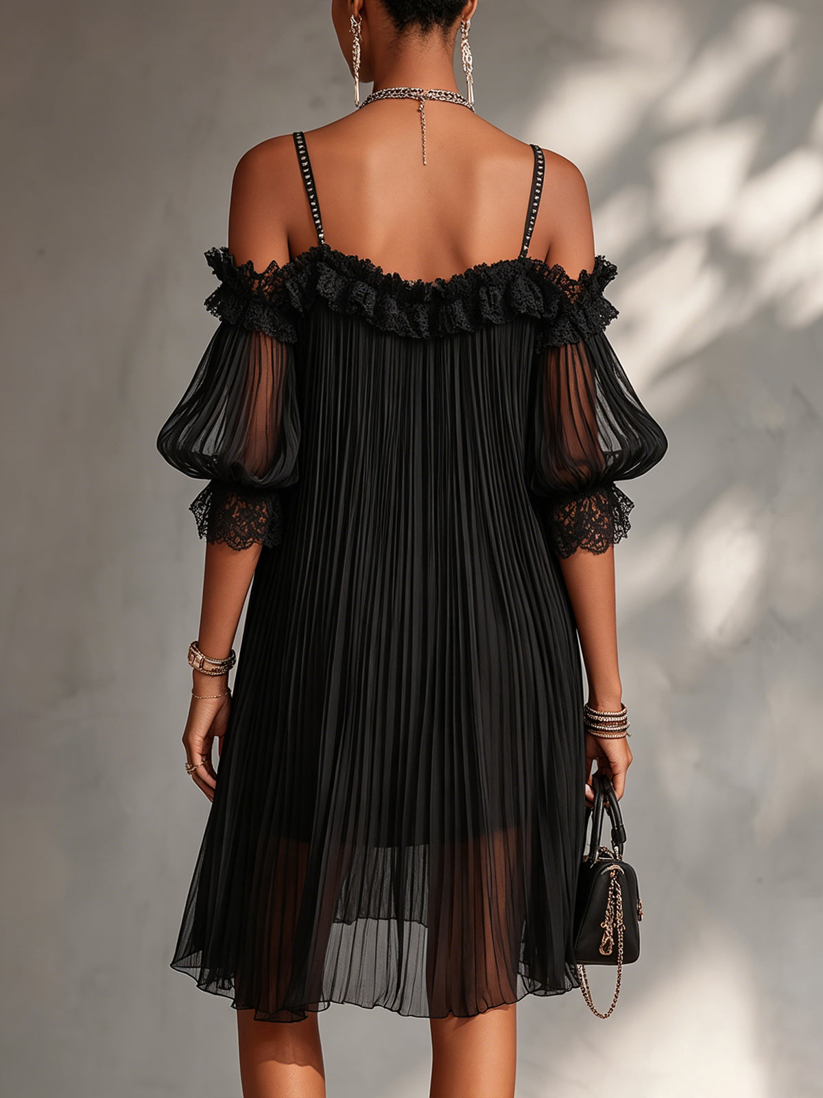 Vestido negro de muselina con espalda descubierta, encaje en hombros y falda plisada