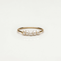 Anillo dorado con mini perlas blancas, banda fina y acabado liso
