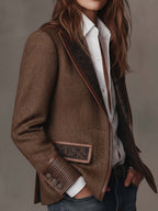 Blazer marrón de espiga con solapa y bolsillo en contraste, vista de hombro y torso.