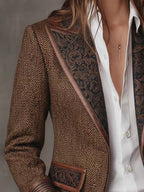 Blazer marrón con espiga y paneles estampados en la pechera, solapas y bolsillo frontal.