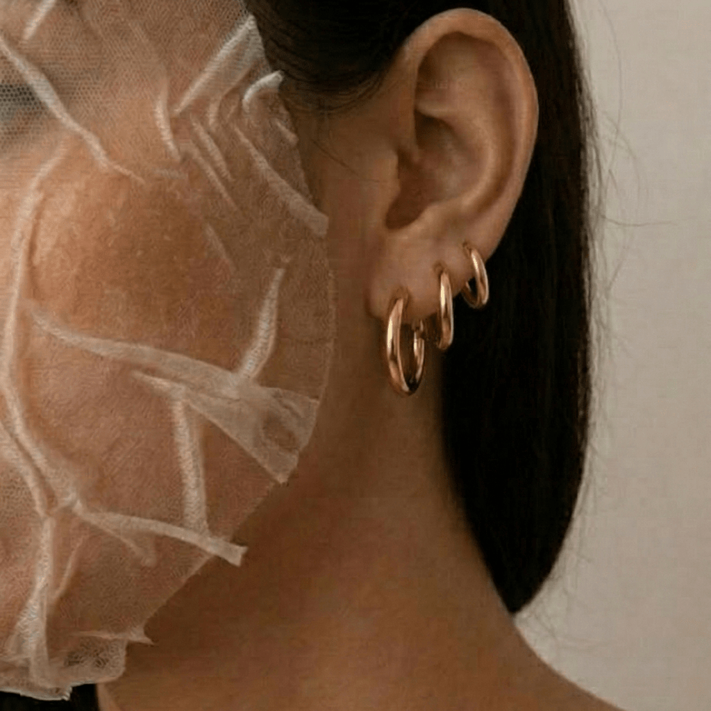 Set de 3 aros tipo argolla dorados en la oreja, con el cabello al lado