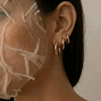 Set de 3 aros tipo argolla dorados en la oreja, con el cabello al lado