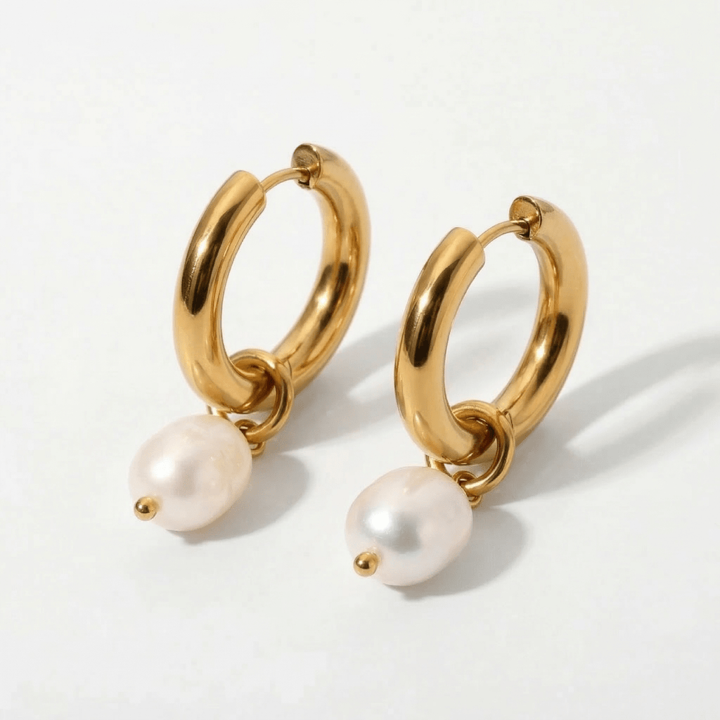 Aros dorados de argolla con perla blanca colgante, fondo liso