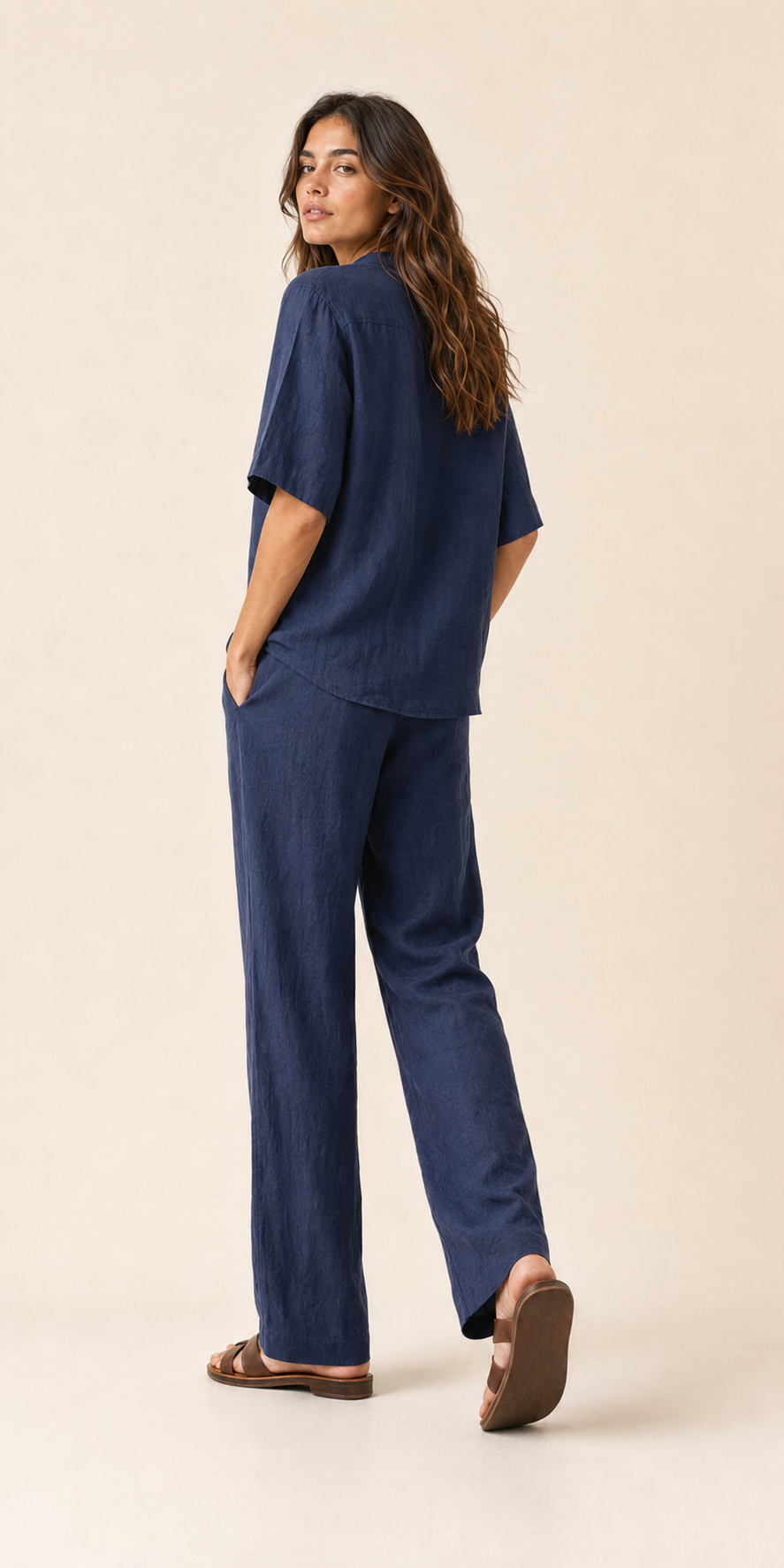 Conjunto de lino azul marino visto de lado: blusa con botones y pantalón holgado.