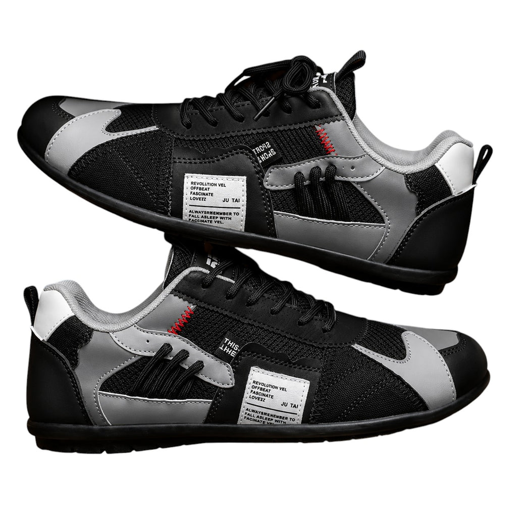 Zapatillas retro negras con paneles grises y blancos, cordones negros y detalle rojo.