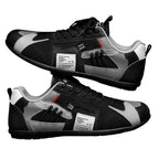 Zapatillas retro negras con paneles grises y blancos, cordones negros y detalle rojo.