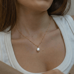 Colgante de perla barroca dorado con perla blanca oval sobre cadena fina