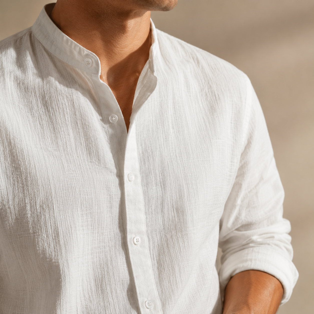 Camisa de lino blanca con botones frontales y cuello mao, detalle del pecho.