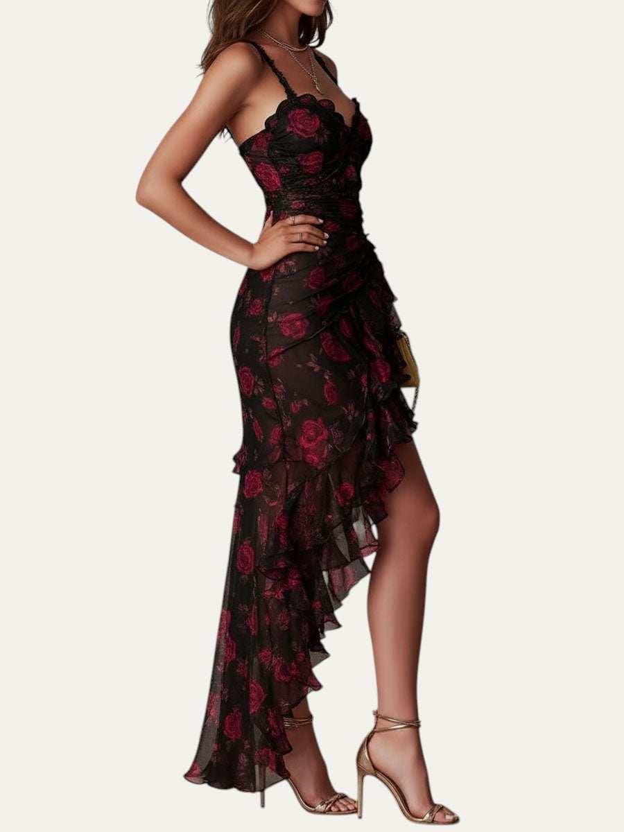 Vestido elegante negro con estampado floral rojo, volantes asimétricos y abertura; vista lateral.