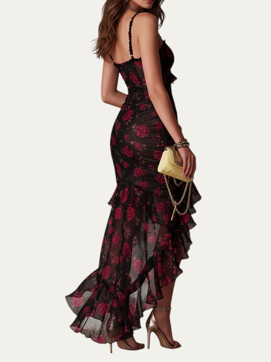 Vestido elegante negro con estampado floral rojo y volantes en capas; vista lateral trasera.