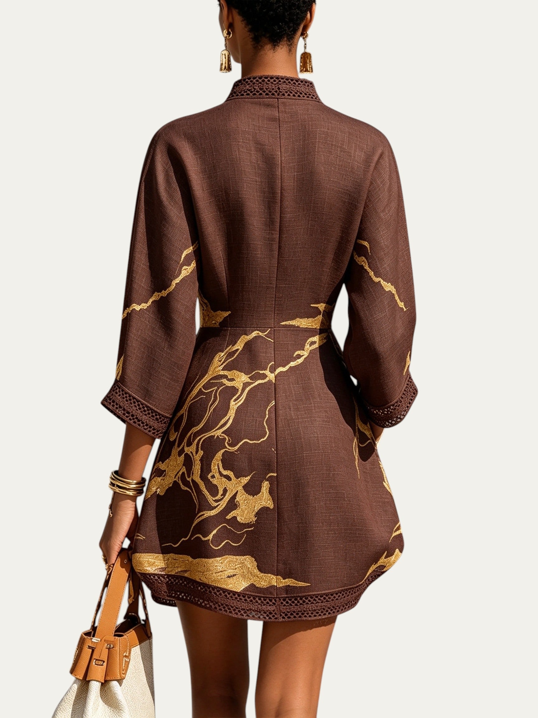 Minivestido marrón con estampado dorado; espalda con encaje en el dobladillo