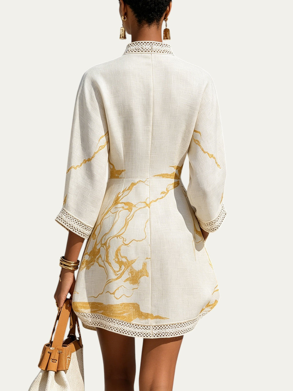Minivestido marfil con estampado dorado; espalda y dobladillo con encaje