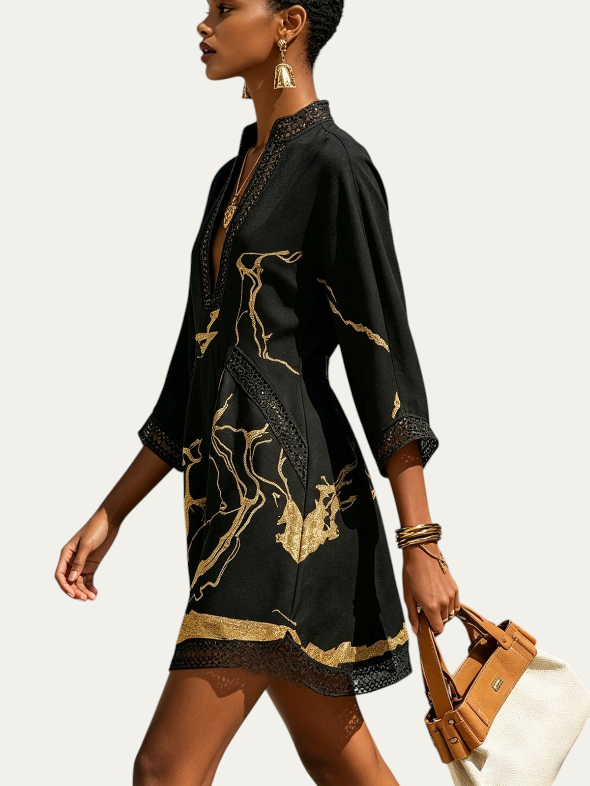 Minivestido negro con estampado dorado, escote V y encaje a crochet en mangas