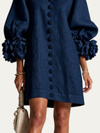 Minivestido azul marino corto con botones frontales, estampado floral y puños de flor