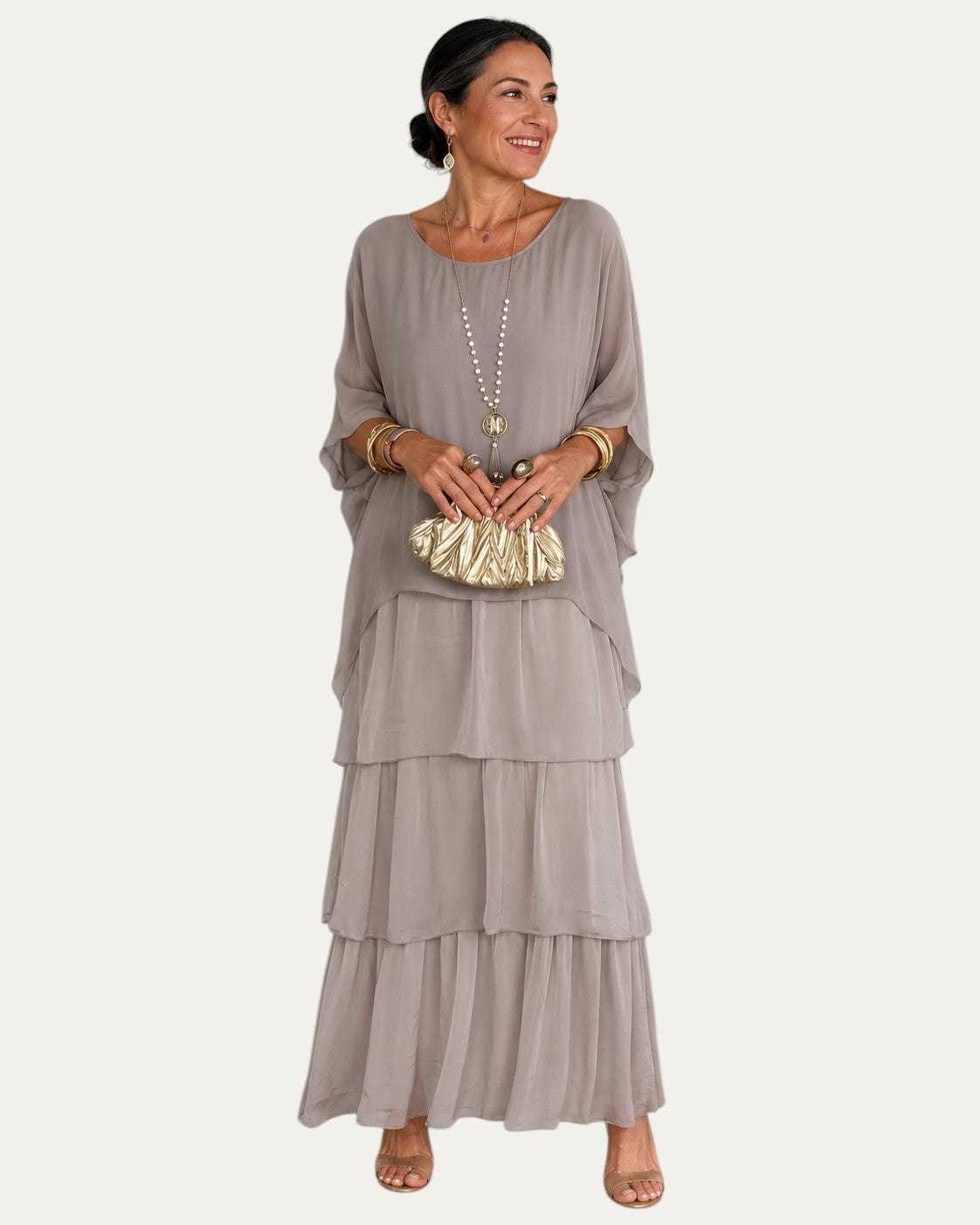 Vestido largo gris claro con volantes escalonados y manga tipo capa, escote redondo.