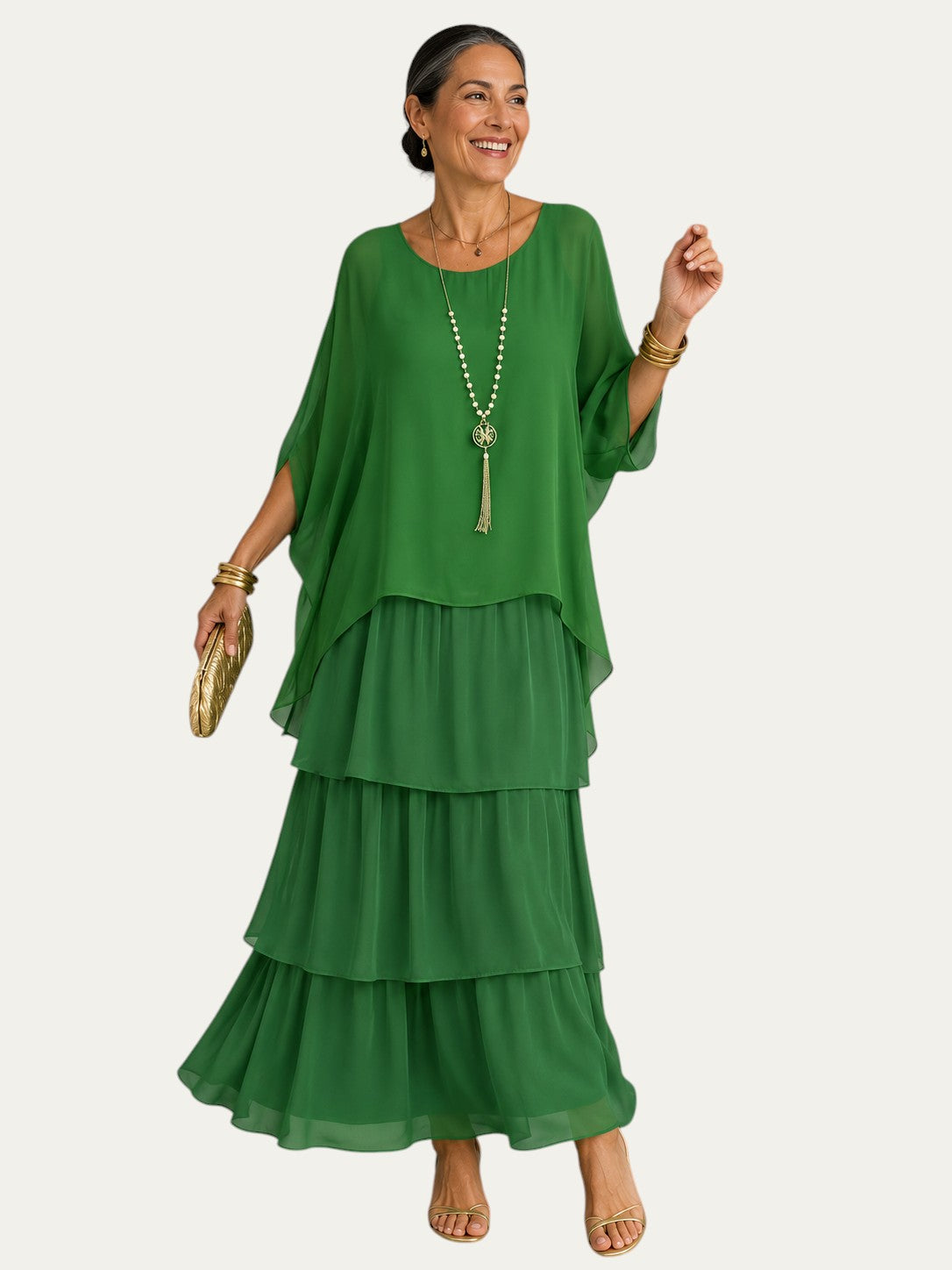 Vestido largo verde con volantes escalonados y mangas tipo capa, escote redondo.