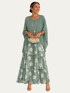Vestido largo verde con bordado de flores en la falda y volantes escalonados.