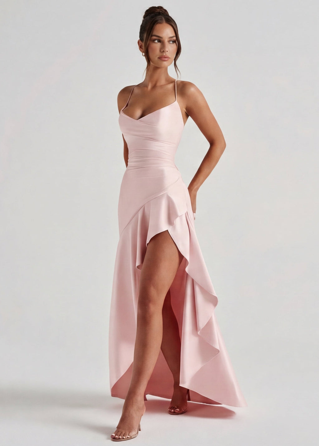 Vestido largo rosa claro con tirantes finos y falda asimétrica con volantes