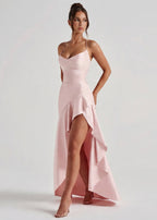 Vestido largo rosa claro con tirantes finos y falda asimétrica con volantes