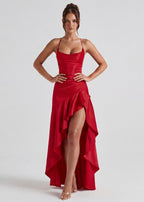 Vestido largo rojo con tirantes finos, corsé entallado y abertura con capas drapeadas