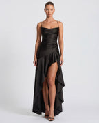 Vestido largo negro con tirantes finos, corsé entallado y falda asimétrica con abertura