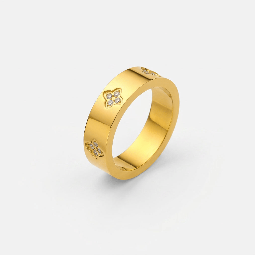 Anillo dorado con detalles de trébol y piedras brillantes en el lateral