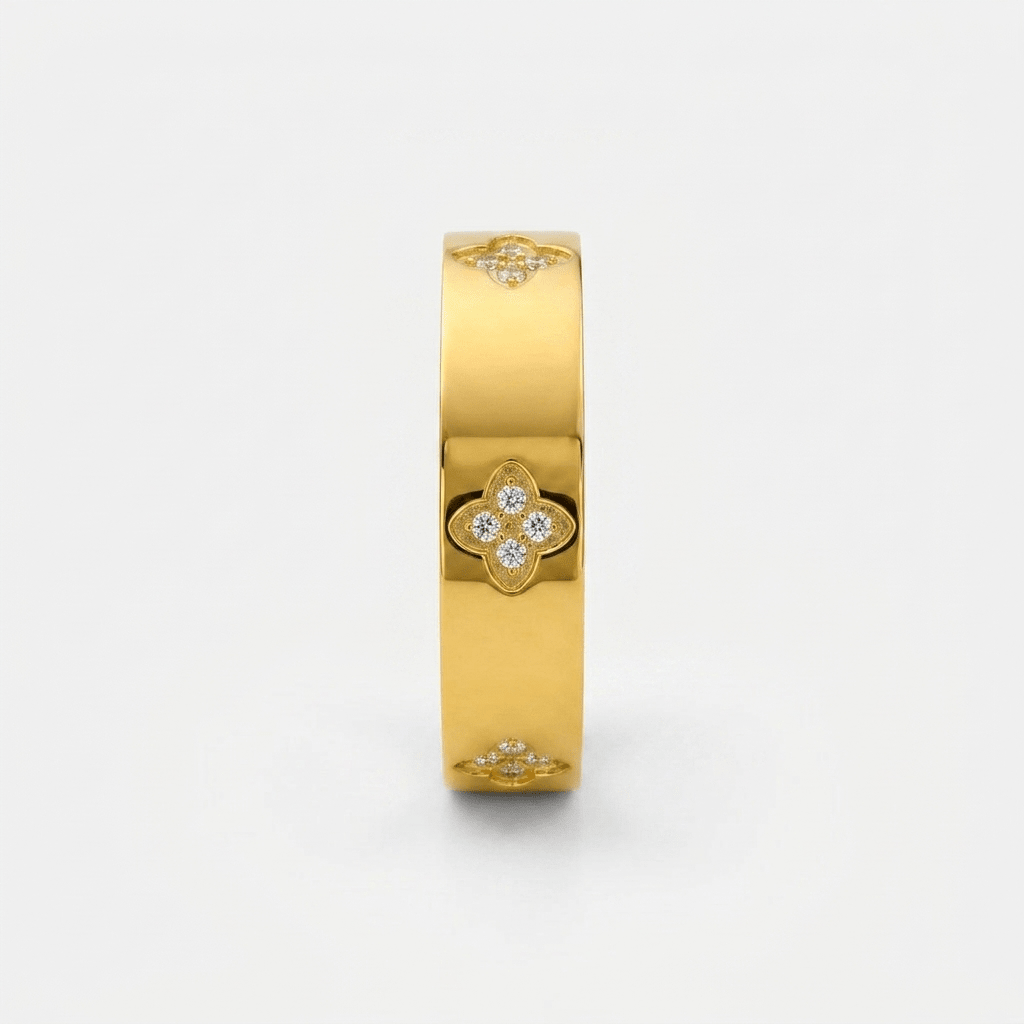 Anillo dorado ancho con tréboles y piedras brillantes visibles en el frontal