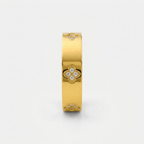 Anillo dorado ancho con tréboles y piedras brillantes visibles en el frontal