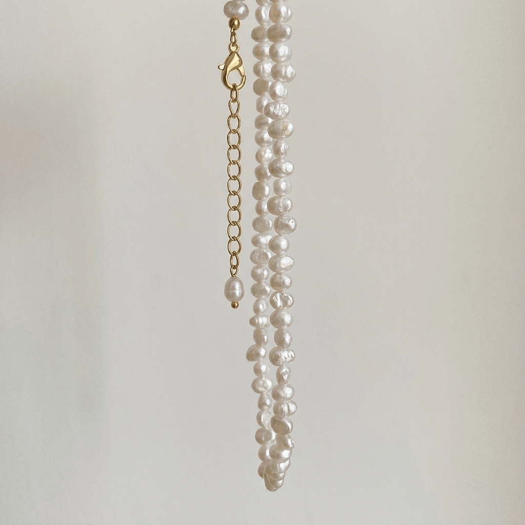 Choker de perlas blancas con cierre dorado y colgante de una perla.