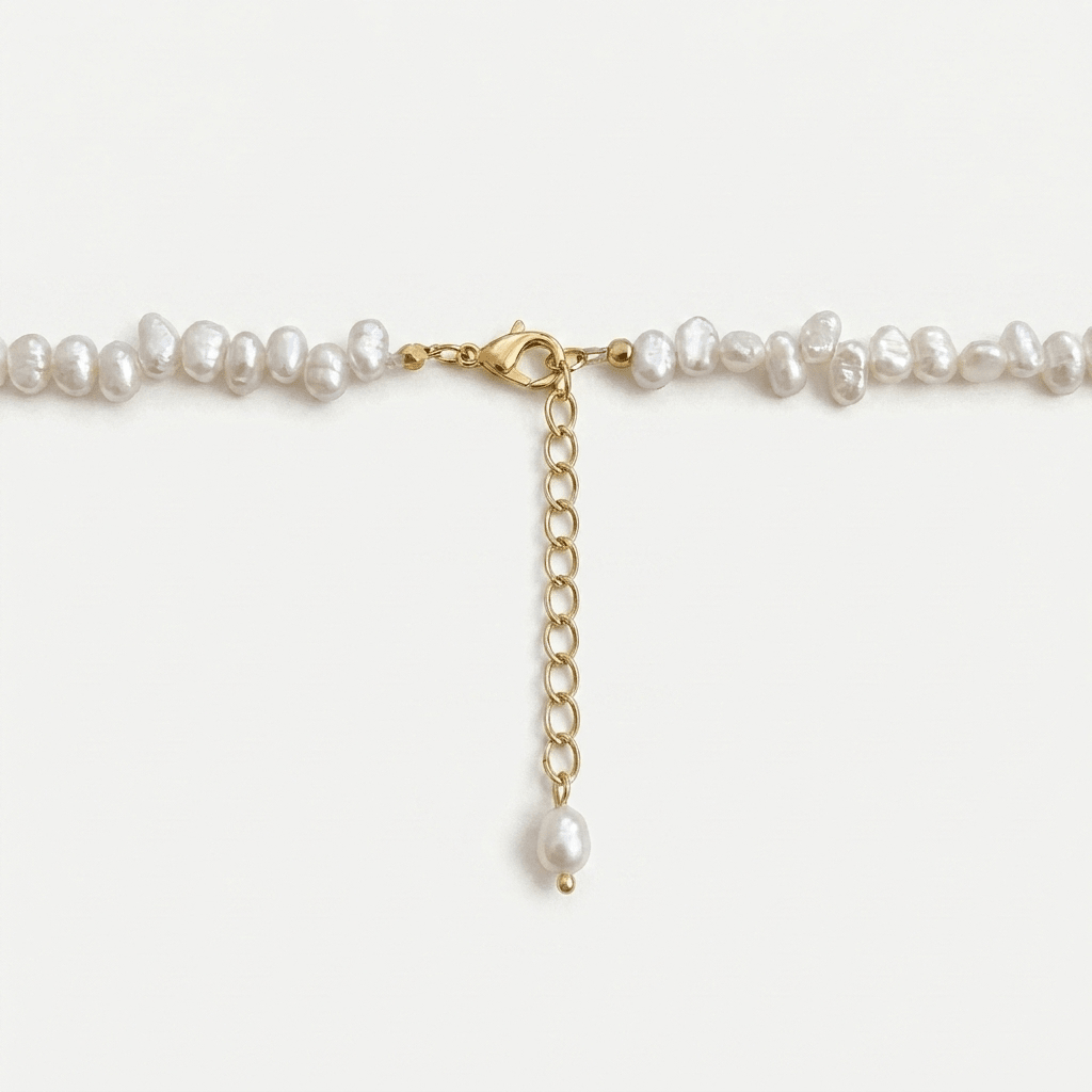 Choker de perlas blancas con cierre dorado tipo cadena y colgante de perla.