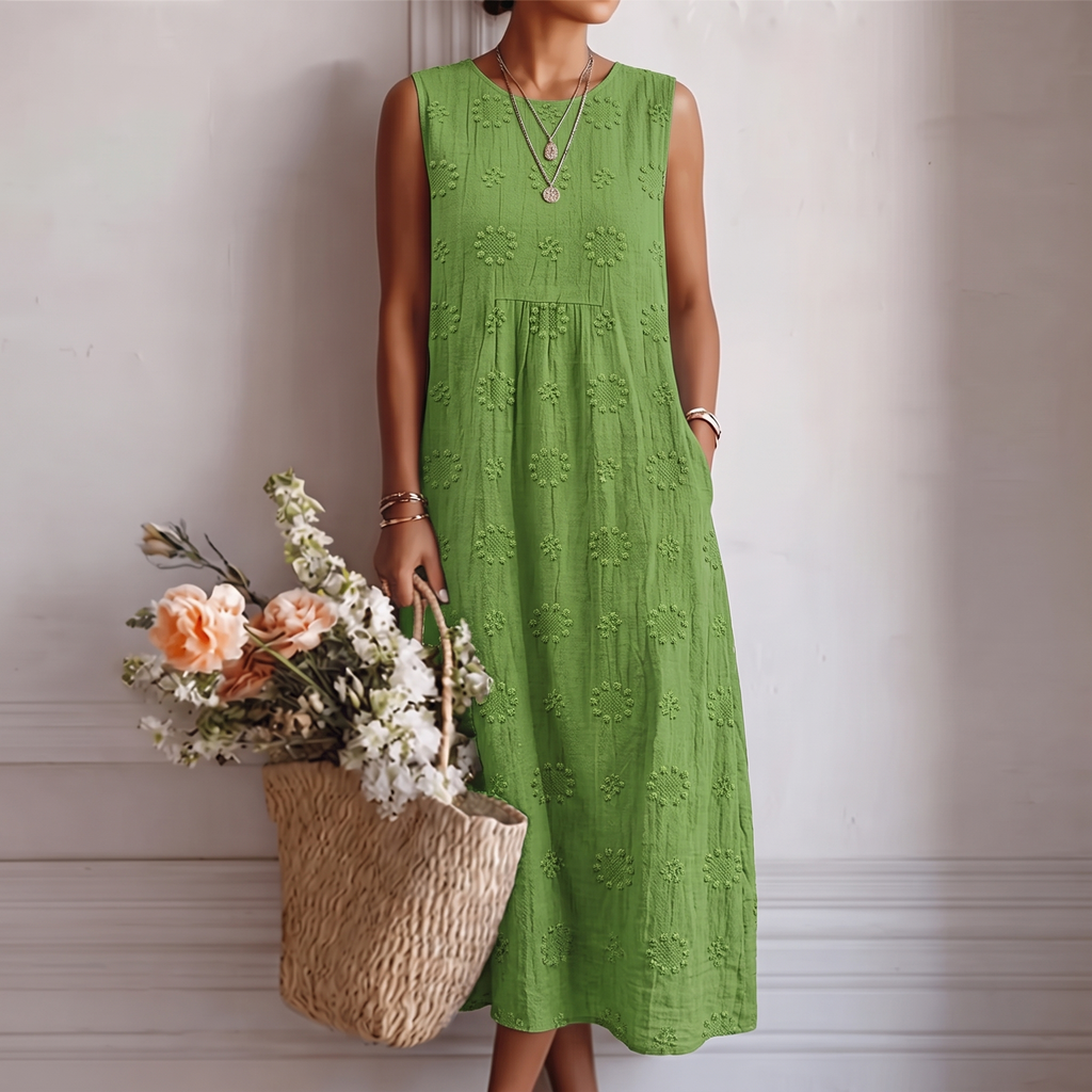 Vestido midi verde sin mangas con patrón de flores, botones en el pecho y falda suelta.
