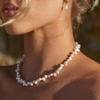 Choker de perlas blancas con detalle de cuentas alargadas y acabado brillante.