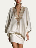 Conjunto de blusa holgada y minifalda blanca con escote en V y bordado dorado