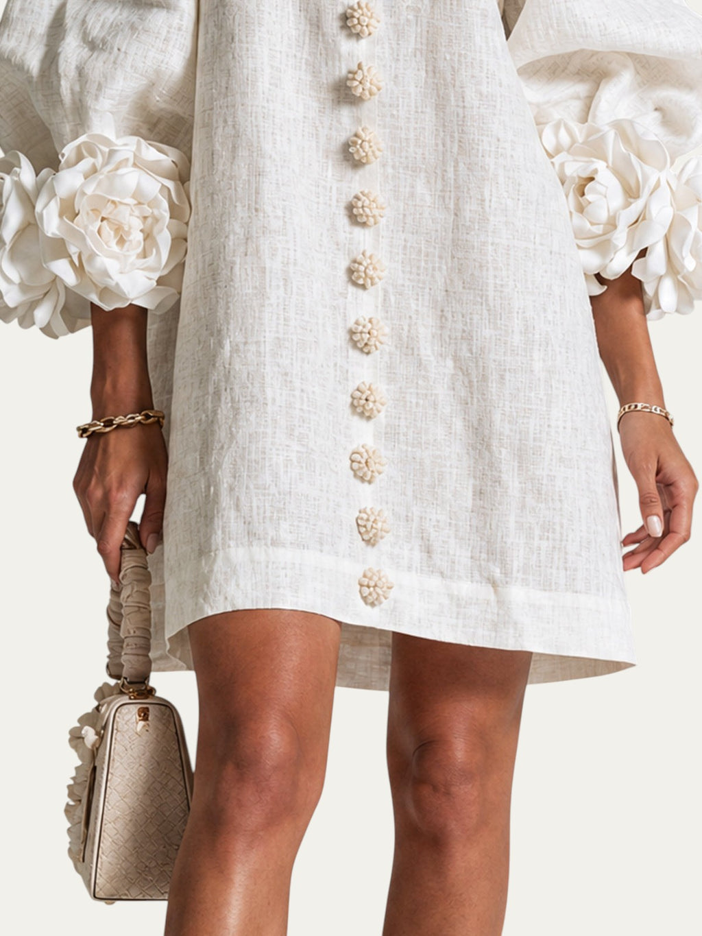 Minivestido corto blanco de lino con botones decorativos en el centro y dobladillo