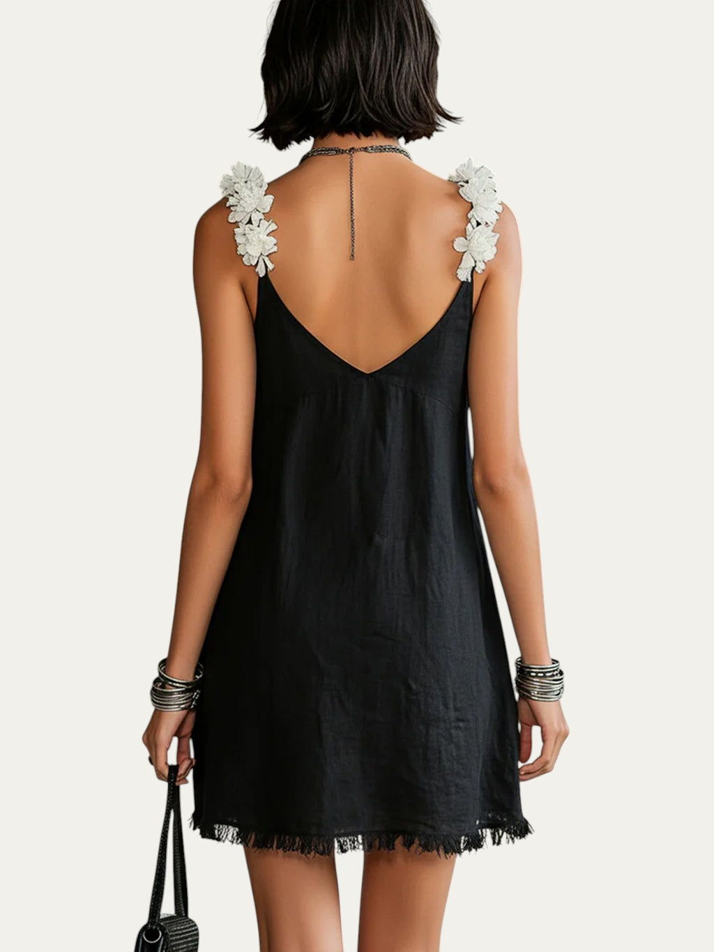 Minivestido negro de espalda descubierta con escote en V y flores en los tirantes
