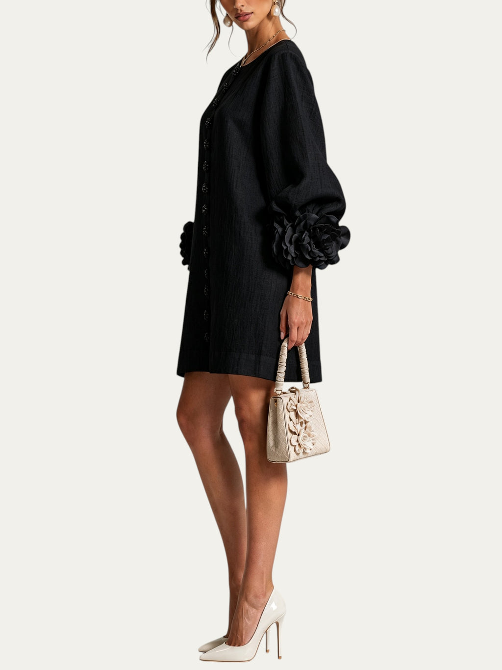 Minivestido negro con botones al frente y puños con flores voluminosas