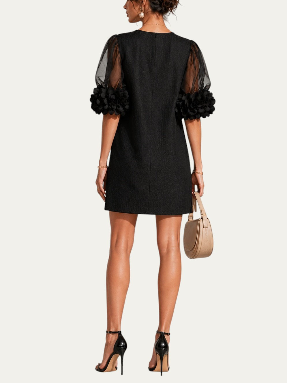 Vestido negro corto de organza, vista trasera, con mangas abullonadas y puños florales