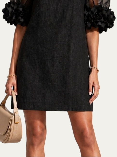 Vestido negro de organza con mangas traslúcidas y puños florales