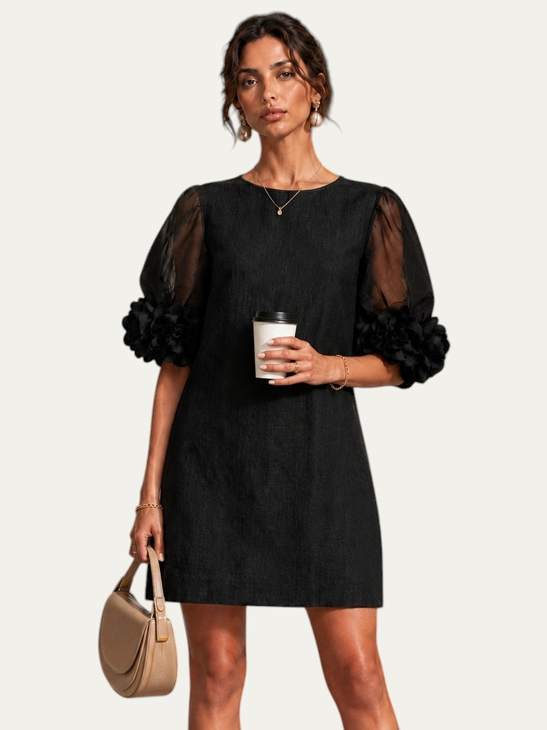 Vestido negro corto de organza con cuello redondo y mangas abullonadas con puños florales