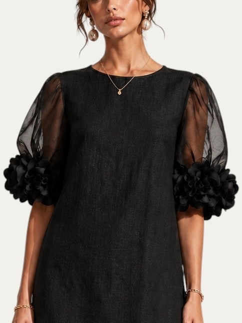 Vestido negro de organza con mangas abullonadas y puños florales voluminosos