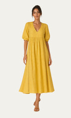 Vestido veraniego amarillo con escote pico, mangas abullonadas y paneles con puntadas