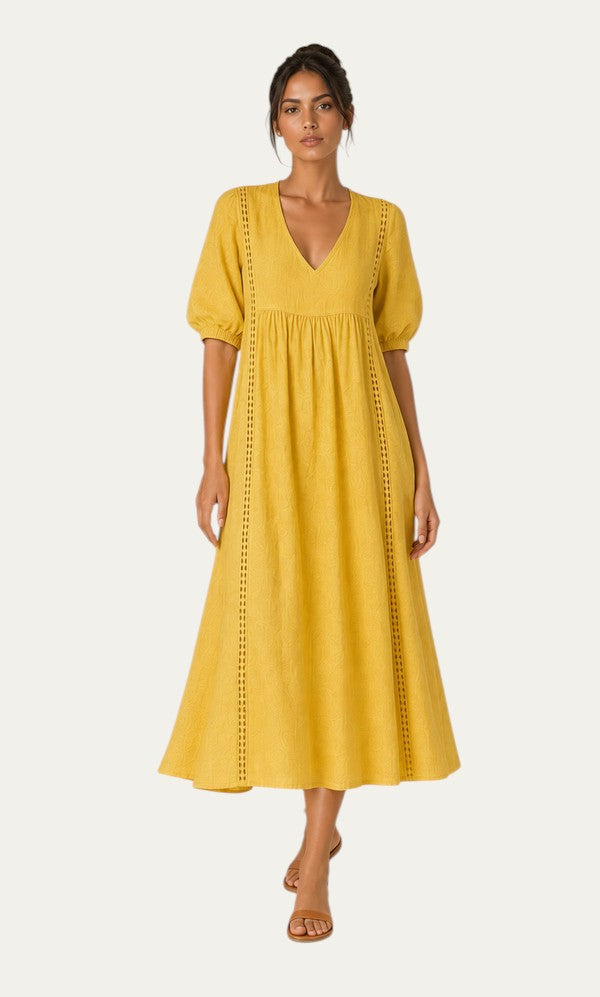 Vestido veraniego amarillo con escote pico, mangas abullonadas y paneles con puntadas
