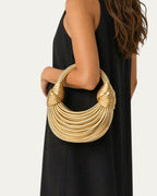 Bolso esencial tipo aro dorado con asas trenzadas y anillos superpuestos