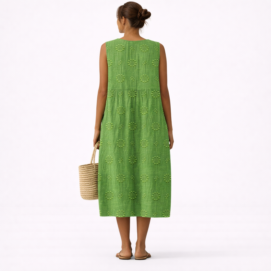 Vestido midi verde sin mangas con espalda lisa y patrón floral repetido, tiro midi.