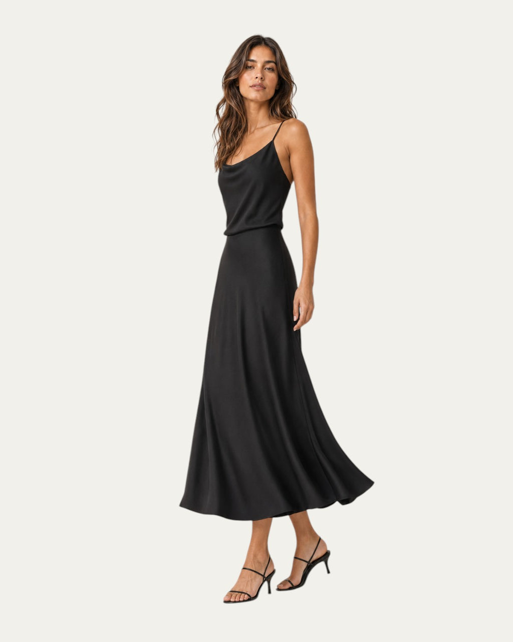 Vestido midi negro de tirantes finos, corte entallado y falda amplia.
