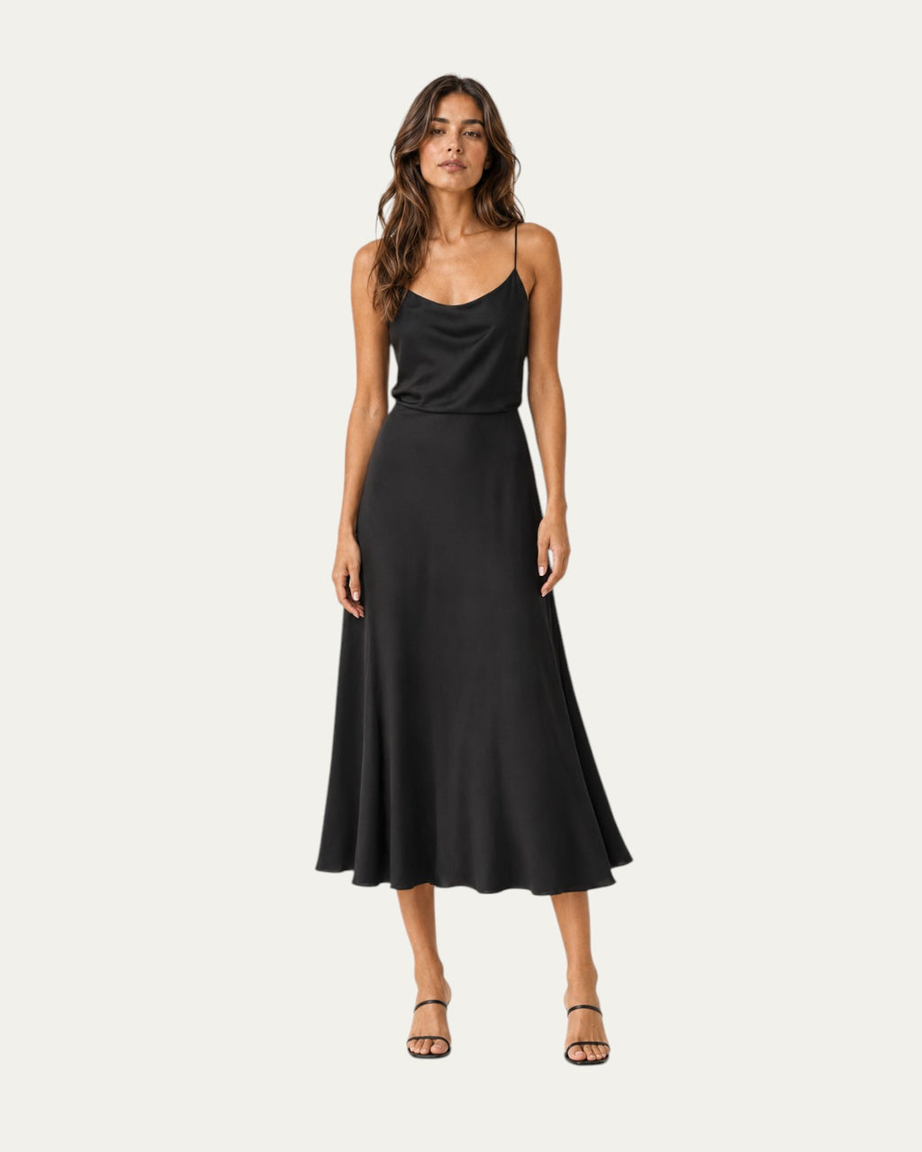 Vestido midi negro liso de tirantes finos y falda con caída fluida.
