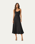 Vestido midi negro liso de tirantes finos y falda con caída fluida.