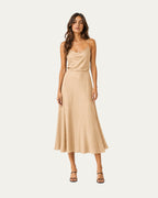 Vestido midi color beige claro de tirantes finos y falda amplia.
