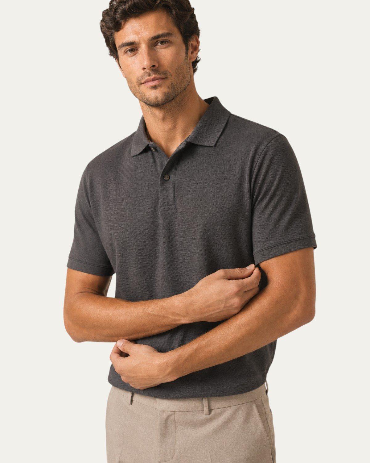 Polo de manga corta gris oscuro, close-up del cuello y placket con botones.
