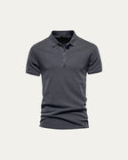 Polo de manga corta azul oscuro, con cuello tipo polo y tapeta de botones.